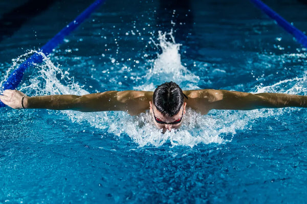 Visuel d'un sportif en piscine faisant de la nage papillon