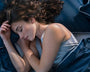 Femme endormie dans un lit avec du linge de lit de couleur bleu marine